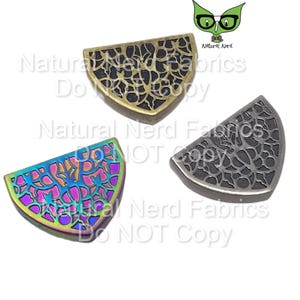 May include: Three metal half-circle shapes with a decorative filigree design. The shapes are in gold, silver, and iridescent colors.