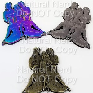 May include: Three metal sculptures of a group of people, each in a different colour. The sculptures are seated with their arms around each other. The sculptures are made of a shiny metal with a rainbow finish, a dark grey finish, and a bronze finish.