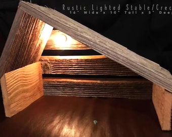 May include: A rustic wooden stable or creche with a lit light inside. The stable is 16 inches wide, 10 inches tall, and 5 inches deep.