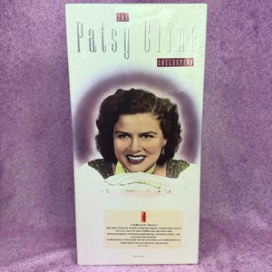 Puede incluir: Una caja rectangular titulada Patsy Cline Collection con un retrato de la artista. El empaque blanco incluye texto que detalla 4 discos compactos, 104 cortes y un folleto de 48 páginas con fotos raras, notas extensas y discografía.