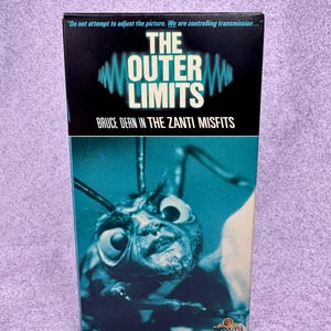 May include: A VHS tape of The Outer Limits episode The Zanti Misfits featuring Bruce Dern. The black cover displays the text Do not attempt to adjust the picture. We are controlling transmission and an image of a creature with large eyes.
