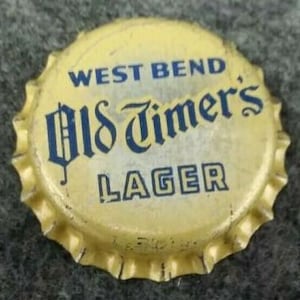 May include: A yellow bottle cap with blue lettering that reads "West Bend Old Timer's Lager".