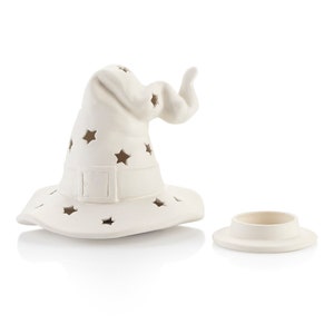May include: White ceramic witch hat with star cutouts. The hat is a candle holder with a separate base.