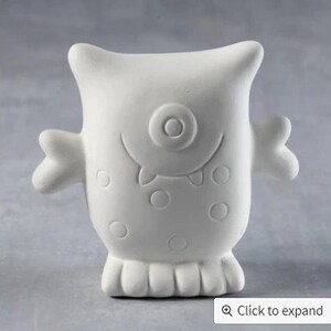 May include: White ceramic monster figurine with a single eye, a toothy grin, and polka dots.