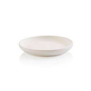 May include: A white ceramic serving dish with a slightly rounded rim. The dish is empty and has a subtle sheen.