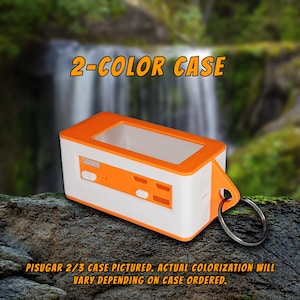 Pode incluir: Uma caixa de dois tons, laranja e branco, com uma janela transparente e um chaveiro. A caixa &eacute; etiquetada com "2-COLOR CASE" e "PISUGAR 2/3 CASE PICTURED. ACTUAL COLORIZATION WILL VARY DEPENDING ON CASE ORDERED."