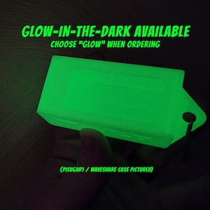 Pode incluir: Uma caixa verde que brilha no escuro para um computador Raspberry Pi. A caixa &eacute; feita de pl&aacute;stico e tem um pequeno furo para um chaveiro. O texto "GLOW-IN-THE-DARK AVAILABLE CHOOSE "GLOW" WHEN ORDERING (PISUGAR1 / WAVESHARE CASE PICTURED)" &eacute; vis&iacute;vel na imagem.