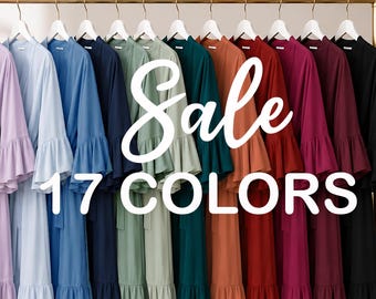 May include: Seventeen robes with ruffled sleeves and waist ties hanging on a gold rack. The robes are available in a spectrum of colors including white, beige, pink, lavender, blue, green, red, burgundy, and black. Text reads Sale 17 COLORS.