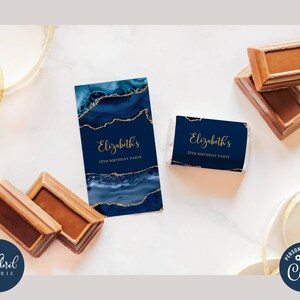 May include: Navy blue and gold party favors with the text "Elizabeth's 18th Birthday Party". The favors have a marble design with gold accents. Chocolate bars are also visible.