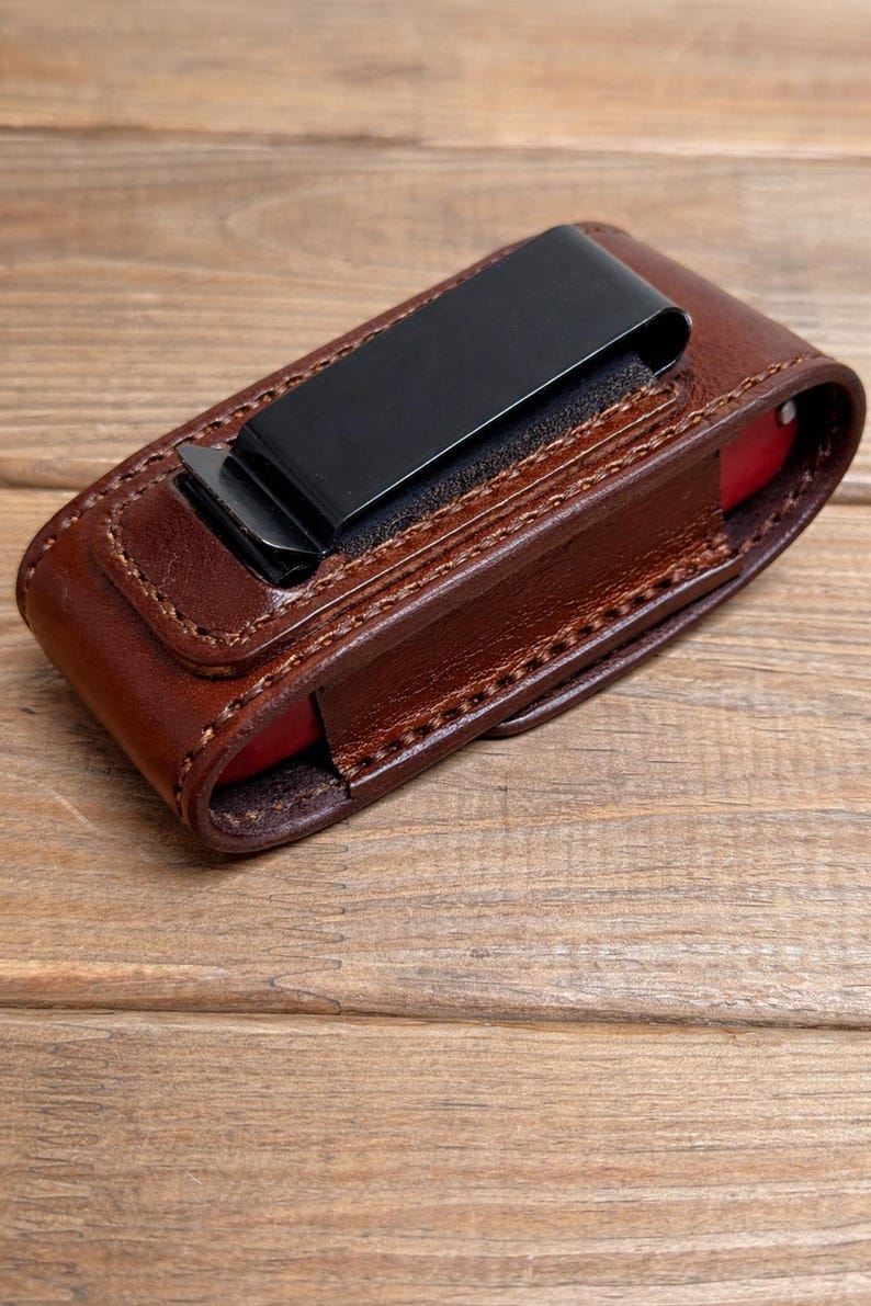 May include: A white ceramic mug with a black handle and the text "But First, Coffee" in a bold, black font. The mug is set against a blurred background, suggesting a cozy setting.