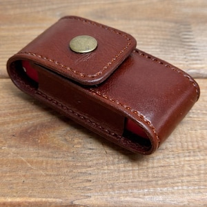 May include: A white ceramic mug with a black handle and the text "But First, Coffee" in a black, bold font. The mug is on a white surface. The mug is approximately 4 inches tall.