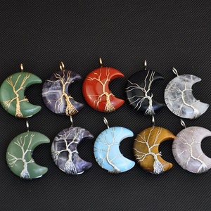 Peut inclure: Dix pendentifs en forme de croissant de lune avec des motifs d'arbres en fil de fer. Les pendentifs sont faits de différentes pierres, notamment de l'aventurine verte, de l'améthyste, du jaspe rouge, de l'onyx noir, du quartz clair, de la turquoise, de l'œil de tigre et du quartz rose.