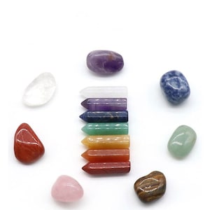May include: Set of seven chakra stones in various colours, including clear quartz, amethyst, lapis lazuli, green aventurine, citrine, carnelian, and red jasper. The stones are arranged in a circle with a row of seven chakra points in the centre.