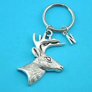 May include: Silver-toned deer head keychain with a silver key ring and a silver charm with the letter N.