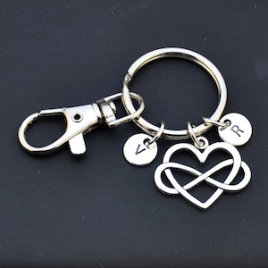 May include: Silver keychain with a heart-shaped infinity symbol charm, two small round charms with the letters "R" and "A", and a silver lobster clasp.