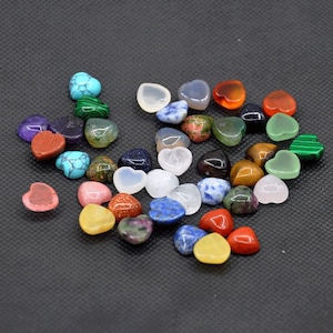 May include: Assortment of small heart-shaped gemstone beads in various colors, including red, green, blue, purple, and white. The beads are made of natural stones and are perfect for jewelry making or crafting.