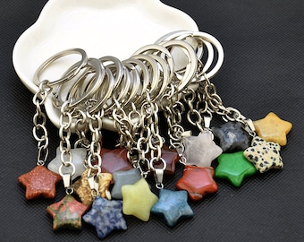 May include: A set of 12 star-shaped keychains made from various types of natural stone. Each keychain features a silver chain and ring.