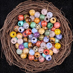 Puede incluir: Una colecci&oacute;n de cuentas de piedras preciosas de colores en varias formas y tama&ntilde;os. Las cuentas est&aacute;n dispuestas en un entorno similar a un nido, mostrando su belleza natural y sus patrones &uacute;nicos.