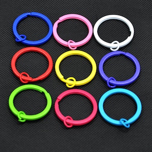 May include: Assortment of ten colourful metal key rings. The key rings are in the following colours: blue, pink, white, red, yellow, purple, green, light blue, and two shades of pink.