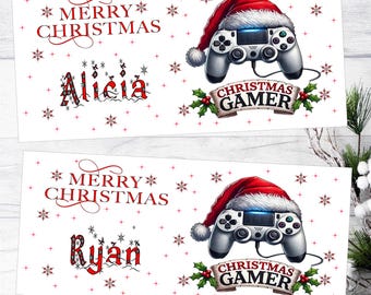 May include: Two rectangular white labels featuring red Merry Christmas text, red snowflake patterns, and a gray video game controller wearing a red Santa hat. Below the controller, a banner reads Christmas Gamer with holly accents.