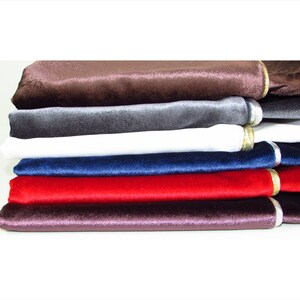 Puede incluir: Un conjunto de seis muestras de tela de terciopelo en varios colores, incluyendo marr&oacute;n, gris, blanco, azul marino, rojo y morado. Cada muestra tiene un ribete dorado en el borde.