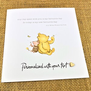 May include: A greeting card featuring Winnie the Pooh and Piglet. The card has the text "Any day spent with you is my favourite day. So today is my new favourite day - A.A. Milne, Winnie the Pooh." The card also says "Personalised with your text."