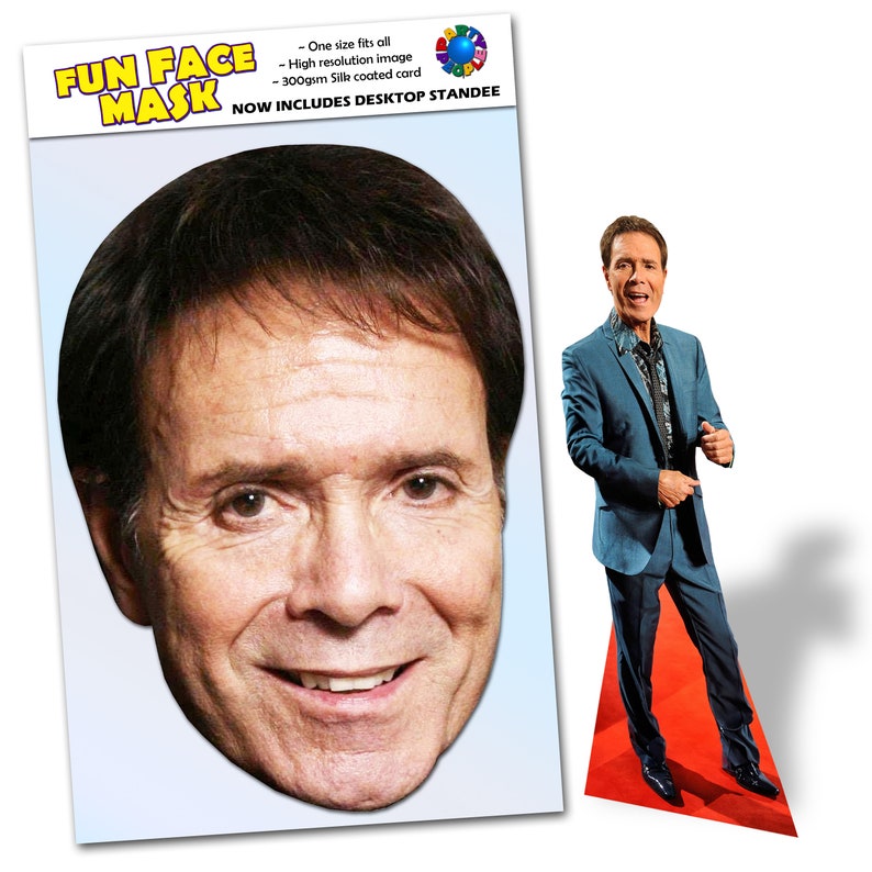 May include: A cardboard cutout of a person's face with a smiling expression. The cutout is designed to be used as a mask. The text "FUN FACE MASK" is printed at the top of the cutout. The text "NOW INCLUDES DESKTOP STANDEE" is printed below the mask.