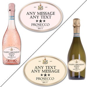 May include: Two oval-shaped labels for champagne bottles. The labels are cream and pink with gold trim. The text on the labels reads "EST. 1883", "ANY MESSAGE ANY TEXT", "PROSECCO", "PRODUCT OF ITALY", "BRUT", and "HAPPY BIRTHDAY SUSAN".