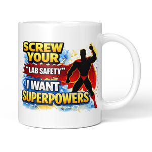 May include: White ceramic mug featuring a superhero design and the text "SCREW YOUR 'LAB SAFETY' I WANT SUPERPOWERS". The superhero is a black silhouette with a red cape. The mug has a white handle.