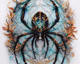 May include: A beaded spider artwork featuring a central spider crafted from black, blue, and gold beads. The spider is positioned over a circular web design in shades of light blue and white, surrounded by intricate, coral-like beadwork in gold and tan.