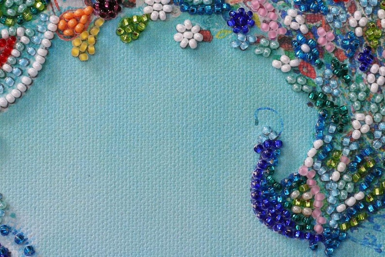 May include: A blue background with a border of colorful beads arranged in a floral pattern. The beads are in shades of blue, green, white, pink, and orange.