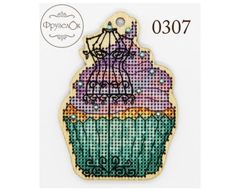 May include: A wooden cupcake ornament with a purple and pink frosting design and a black silhouette of a dress inside. The cupcake is decorated with small, white beads. The ornament has a hole at the top for hanging and the text "0307" is printed on the right side.