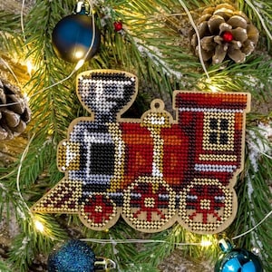 May include: A red, black, and gold train ornament with a wooden base. The train is decorated with beads and sequins. The ornament is perfect for a Christmas tree.