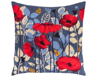 May include: A square throw pillow featuring a needlepoint design of vibrant red poppy flowers with black centers. The background is a dark blue shade filled with light blue and cream-colored foliage, stems, and leaves in a repeating pattern.