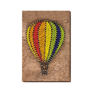 May include: A colorful hot air balloon made of string art on a wooden background. The balloon is red, orange, yellow, green, and blue.