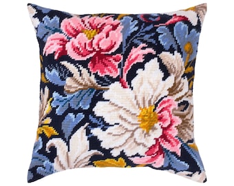 May include: A square needlepoint pillow featuring a dark navy blue background with a vibrant floral pattern. The design includes large white and pink flowers with yellow centers, accented by light blue and tan leaves throughout the composition.