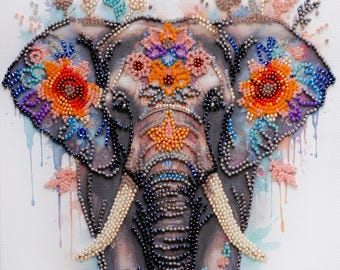 May include: A square canvas wall art piece featuring a detailed elephant head illustration embellished with colorful beads. The elephant is decorated with orange, red, and purple floral patterns on its ears and forehead, with beaded tusks and trunk.