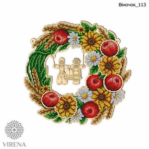 Può includere: Una ghirlanda di legno con uno schema di colori rosso, bianco e verde. La ghirlanda è decorata con girasoli, mele, grano e due piccole figure di legno. Il testo "Віночок_113" è stampato nella parte superiore dell'immagine.