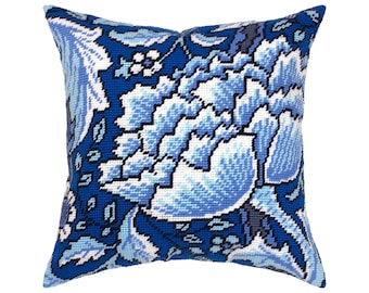 May include: A square needlepoint throw pillow featuring a dense, intricate floral pattern in shades of royal blue, light blue, and white. The design consists of large, stylized blossoms and leafy foliage covering the entire surface of the cushion.