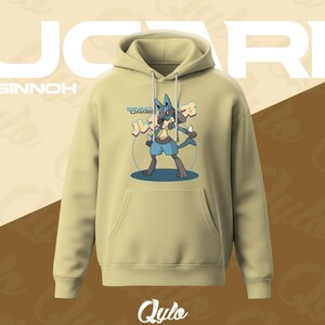 Puede incluir: Una sudadera con capucha verde oliva claro con un gr&aacute;fico de Lucario. El dise&ntilde;o incluye la palabra "Lucario" en letras blancas grandes, la palabra "Sinnoh" encima de la sudadera con capucha y el nombre de la marca "Qulo" en la parte inferior. El gr&aacute;fico de Lucario es azul, gris y beige.