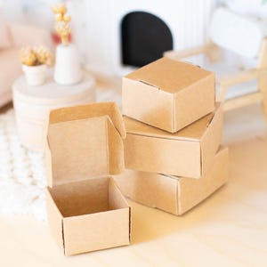 May include: Four brown cardboard boxes stacked on top of each other. The top box is open and the other three are closed.