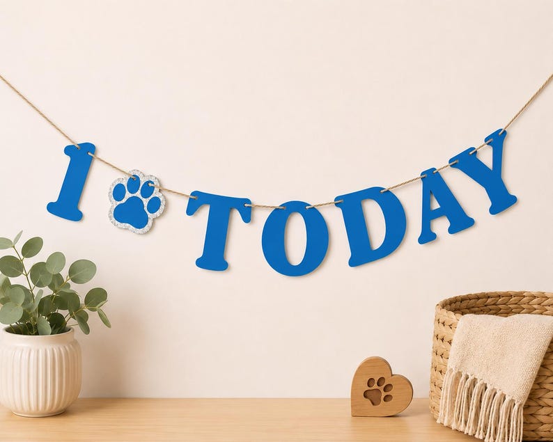 Puede incluir: Una pancarta azul que deletrea la palabra 1 TODAY con un icono de huella reemplazando la letra O. Las letras est&aacute;n ensartadas en un cordel marr&oacute;n fino. La pancarta presenta letras may&uacute;sculas en negrita de un color azul s&oacute;lido con acabado brillante.