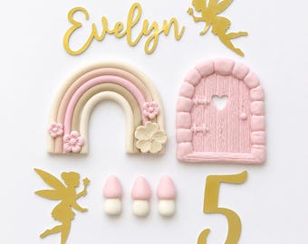 Edible fairy cake topper decoration. Fairy door, toadstools, windows, pebbles, flowers and leaves. fondant sugar paste