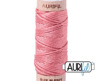 May include: A spool of pink cotton thread with the brand name "Aurifil" printed on the wooden spool. The thread is wound tightly and is ready for sewing.