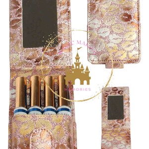May include: A gold and pink glitter makeup case with a mirror and four slots for lipstick tubes. The case has a floral design with a gold clasp.