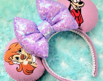 May include: Purple Minnie Mouse ears with a sequined bow and embroidered images of Goofy and a Dalmatian on the ears.