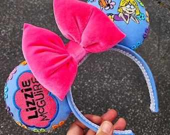 May include: Blue and pink Minnie Mouse ears with a pink bow and a blue embroidered patch that says "Lizzie McGuire".