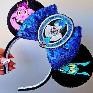 Puede incluir: Diadema azul y negra con un lazo de lentejuelas azules y tres parches bordados con personajes de H&eacute;rcules de Disney. Los parches incluyen a Hades, Dolor y P&aacute;nico.