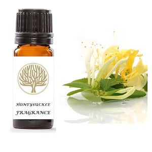 May include: A small amber glass bottle with a black cap, labeled "Honeysuckle Fragrance". The bottle is sitting on a white background with a stylized tree logo. A cluster of white and yellow honeysuckle flowers with green leaves is shown in the background.
