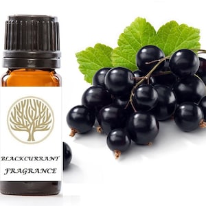 Può includere: Un piccolo flacone di vetro ambrato con un tappo nero e un'etichetta bianca. L'etichetta presenta un disegno di albero dorato e il testo "BLACKCURRANT FRAGRANCE". In background è mostrato un grappolo di ribes nero con foglie verdi.